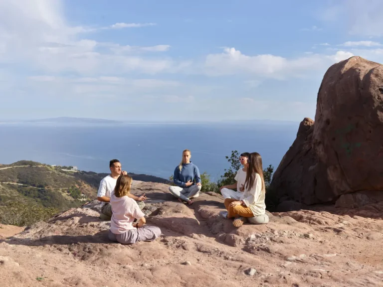 People Meditating on a Cliff